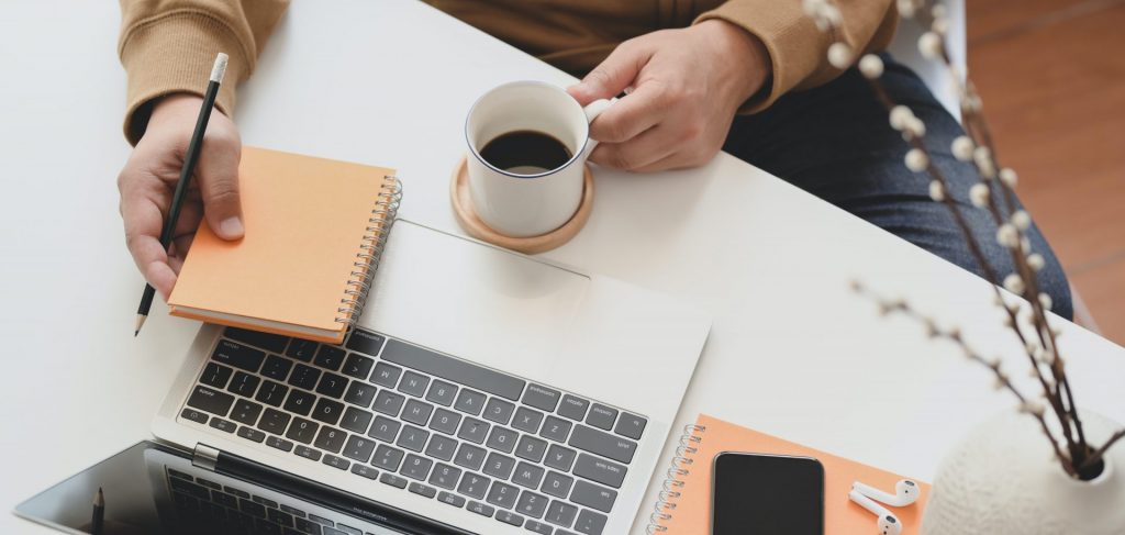 Person sat at home with a coffee filling out an online form