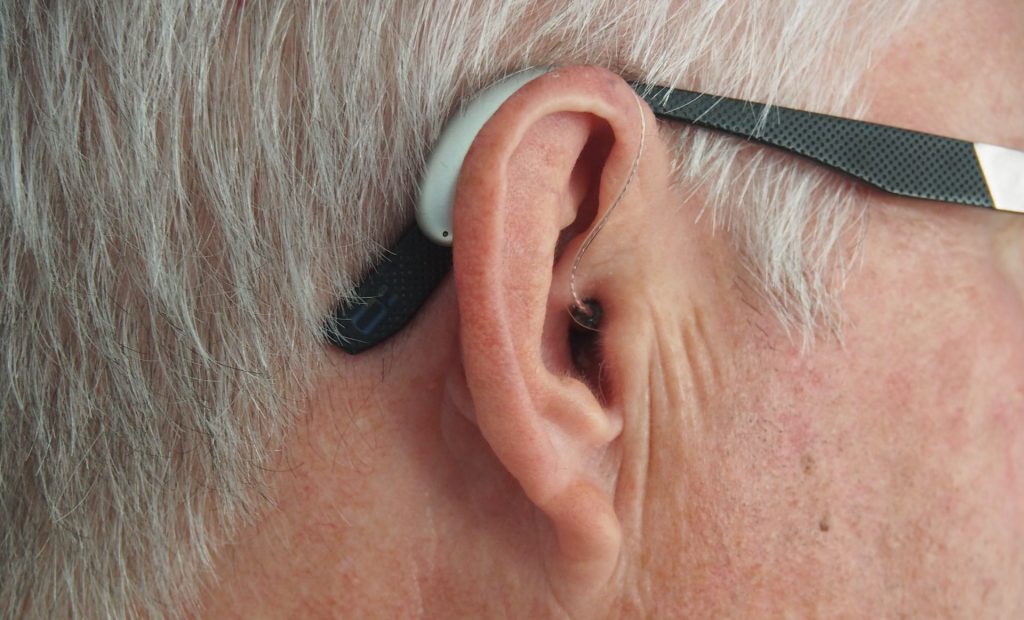 Old man with a hearing aid in