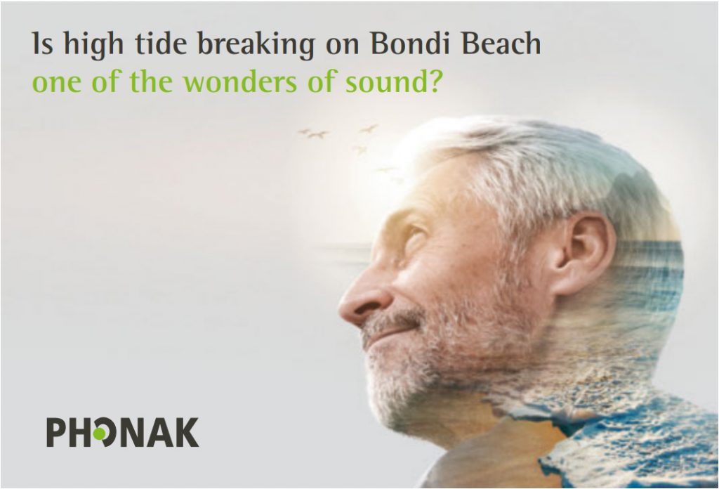 A man listening to the waves on a beach through a phonak paradise