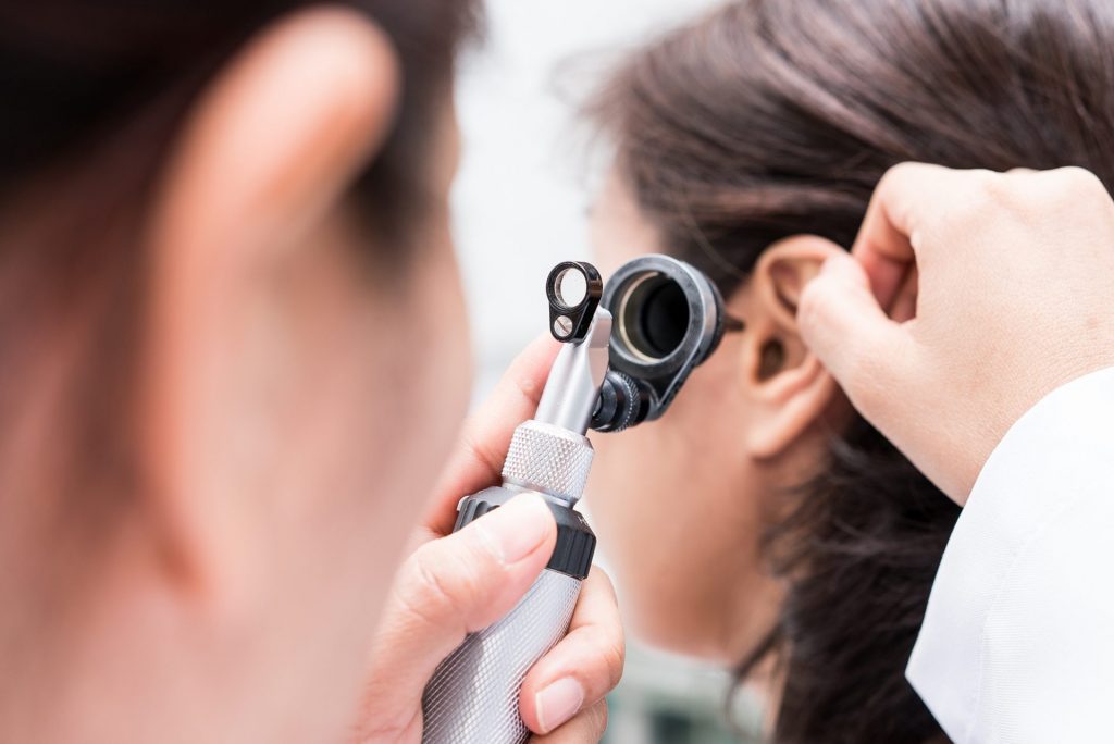 An audiologist conducting an ear exam