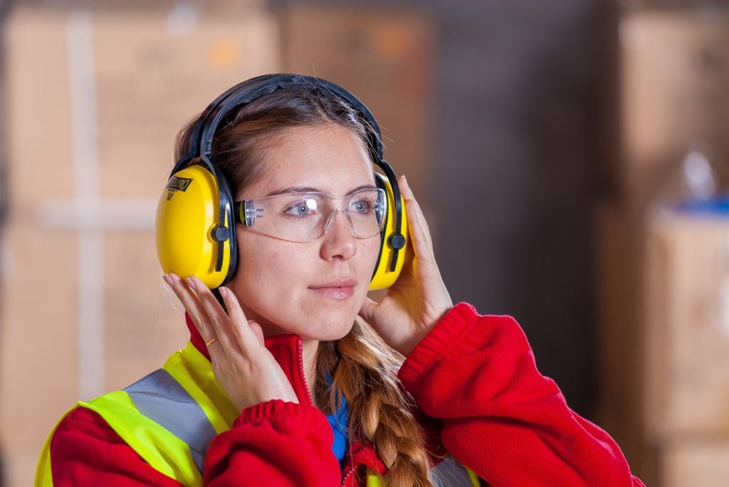 A professional woman using proper hearing protection to prevent tinnitus