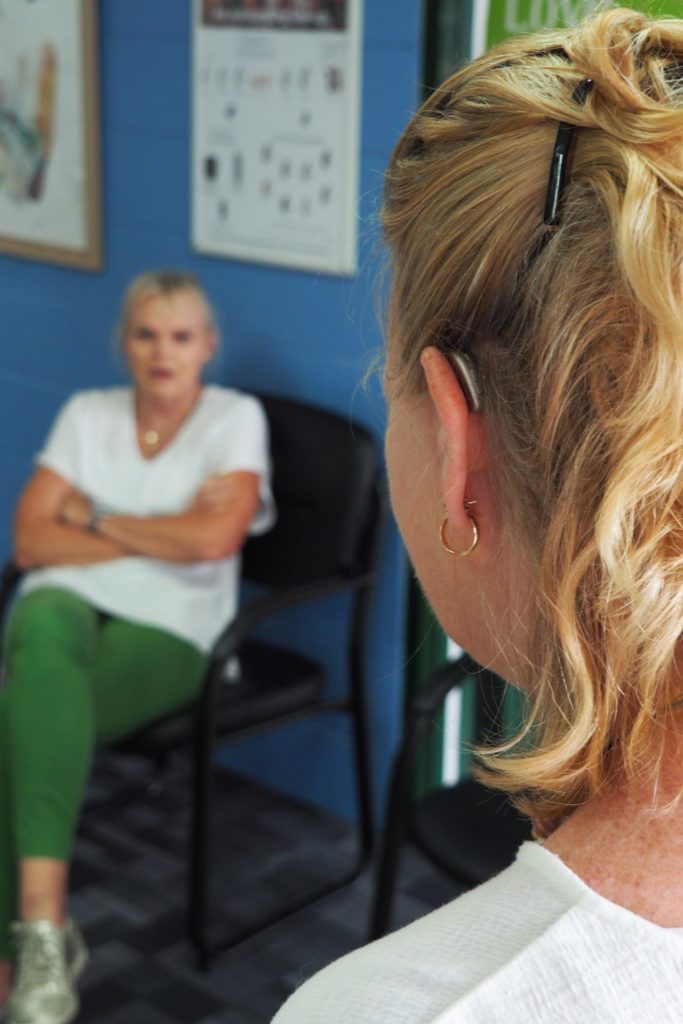 Woman in conversation with behind the ear hearing aid fitted