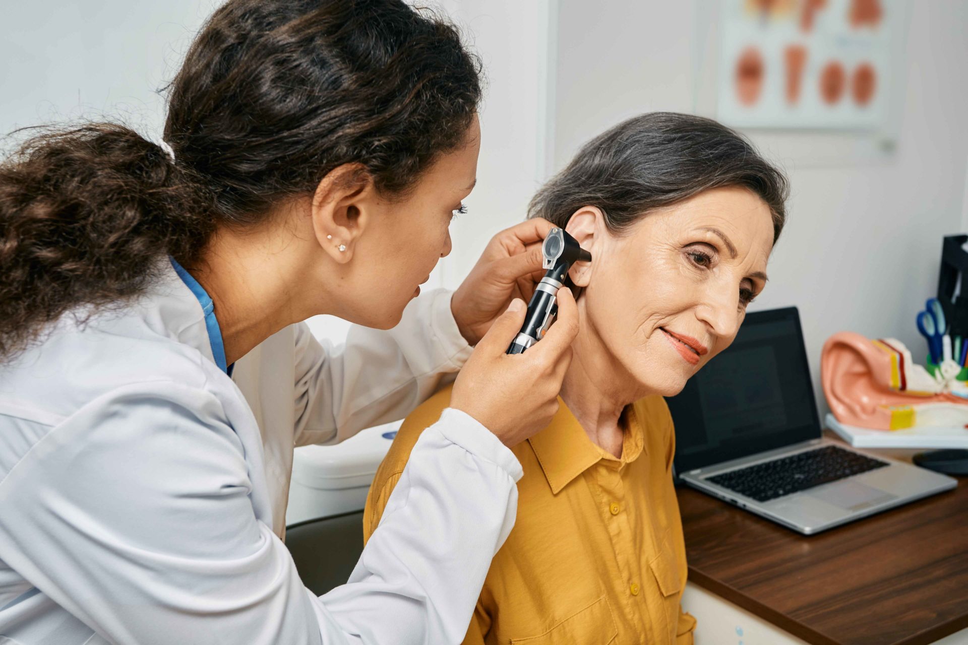 woman getting ears checked for ear wax removal by professional audiologist