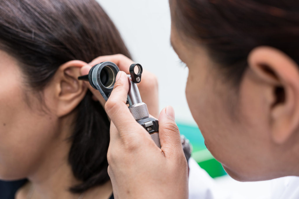 Woman taking out hearing test procedure and looking for signs of hearing loss