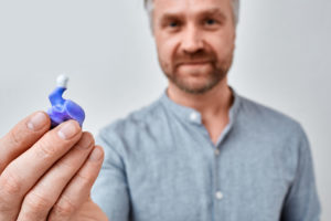 a guy holding a custom ear plug